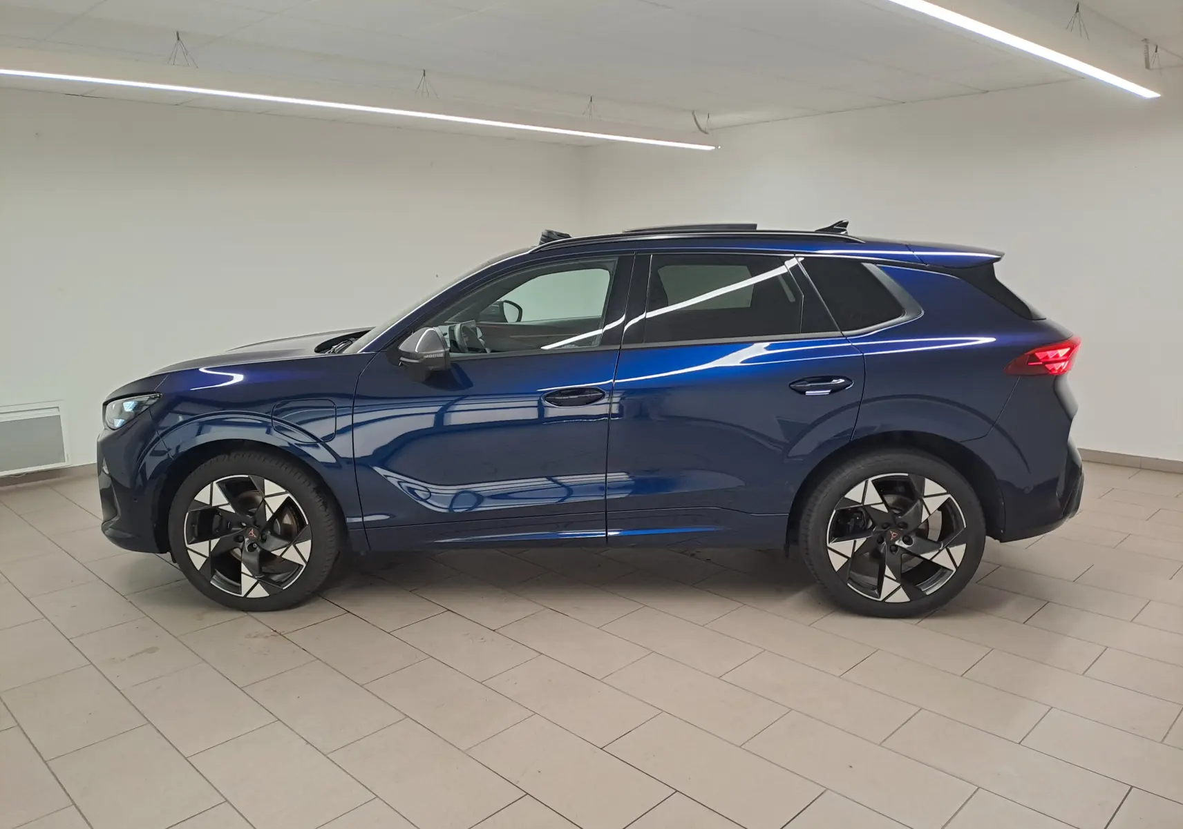 Vue de profil côté gauche du CUPRA TERRAMAR 1.5 eHybrid bleu cosmos avec jantes 20'' Gravity et toit panoramique.