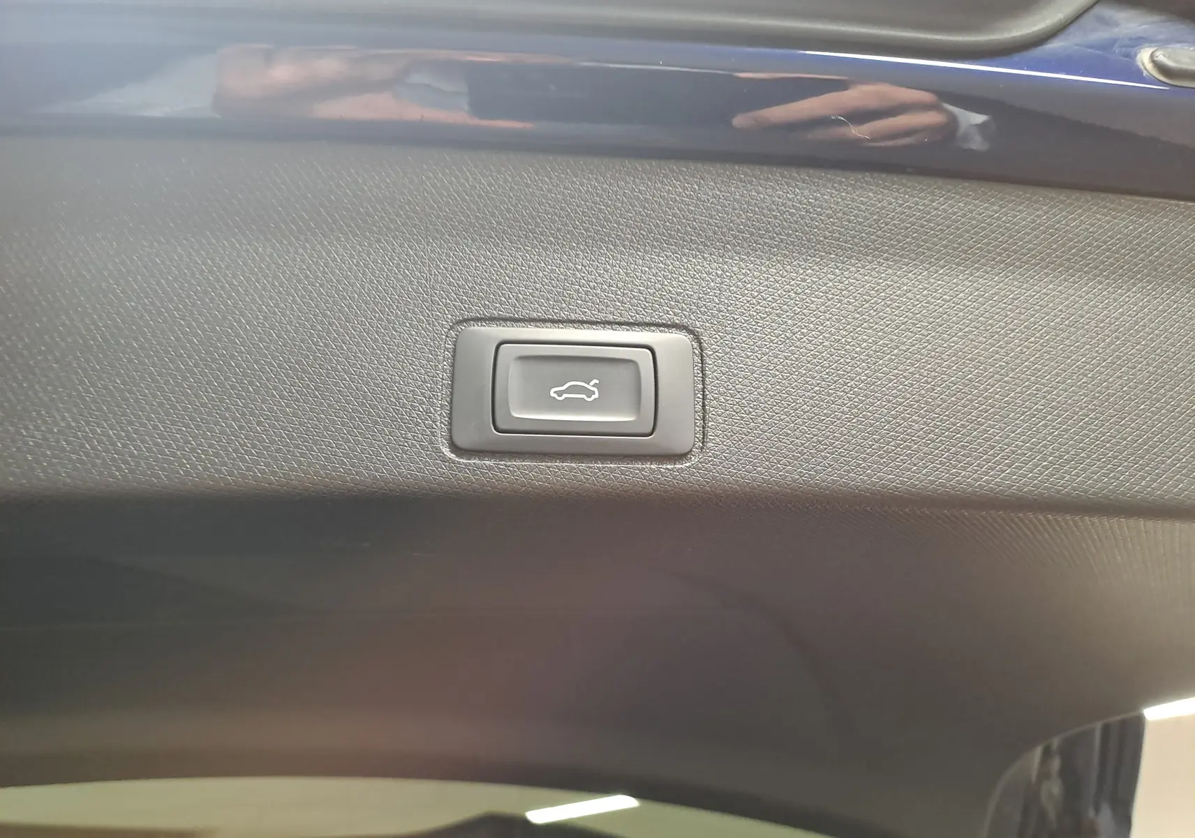 Bouton d'ouverture électrique du coffre sur la partie intérieure du hayon d'une CUPRA TERRAMAR bleu cosmos.