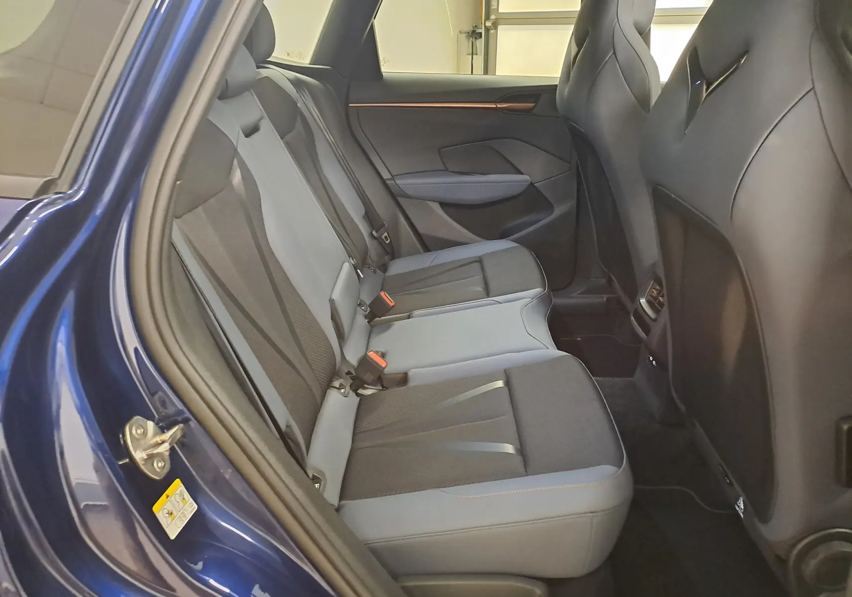 Vue intérieure côté gauche des sièges arrière du CUPRA TERRAMAR bleu cosmos, avec sellerie bicolore et finitions modernes.