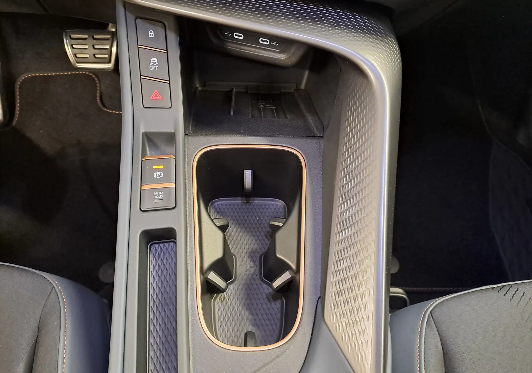 Vue plongeante sur la console centrale de la CUPRA TERRAMAR 1.5 eHybrid avec porte-gobelets et commandes électroniques.