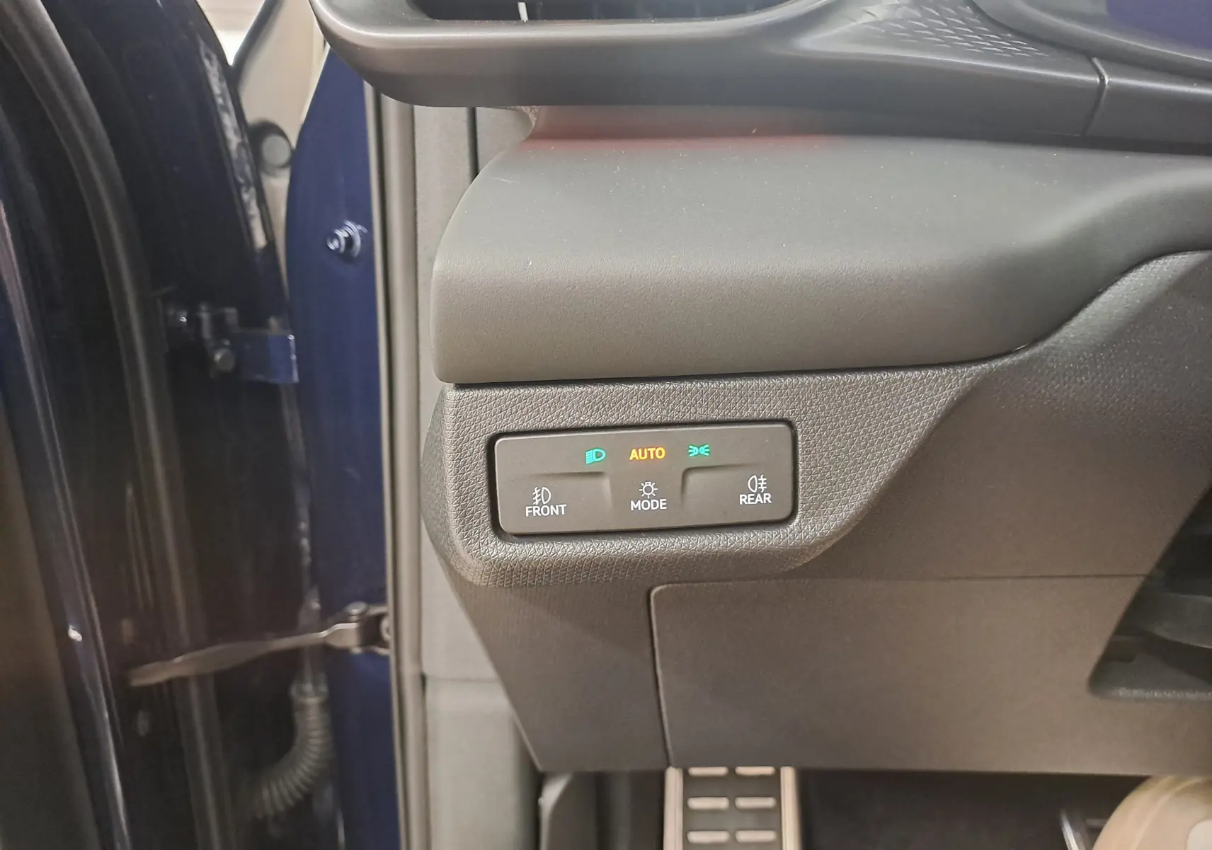 Vue intérieure côté gauche du tableau de bord d'une CUPRA TERRAMAR bleu cosmos, avec commandes éclairage activées.