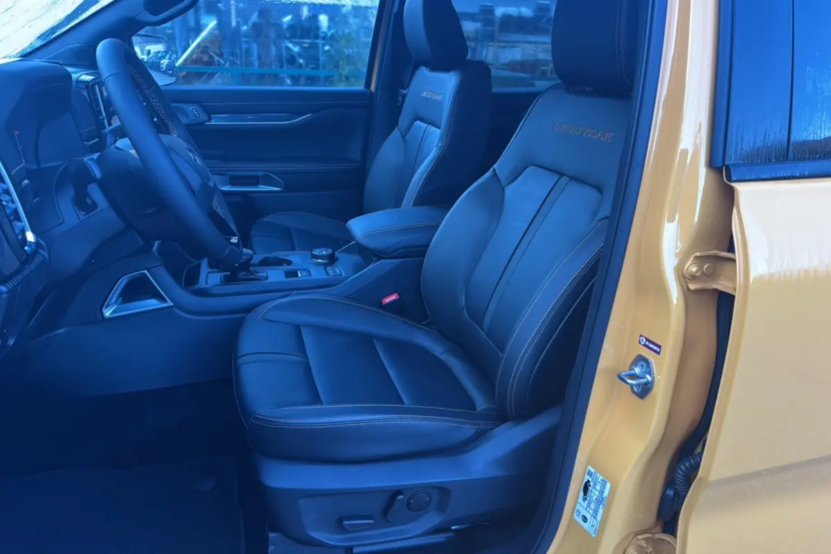 Vue intérieure côté conducteur du Ford Ranger Cyber orange 2026, sièges cuir noirs avec logo Wildtrak brodé.