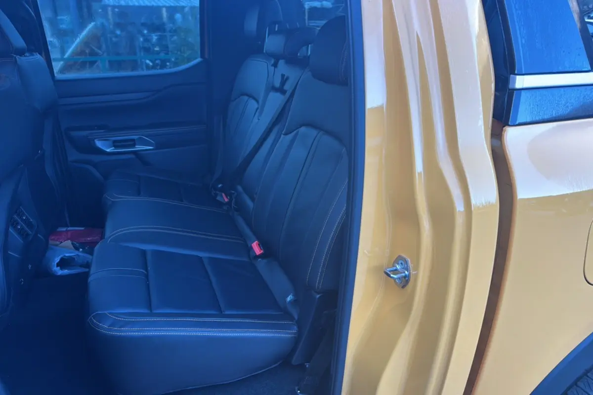 Vue intérieure côté gauche montrant la banquette arrière en cuir noir du Ford Ranger Cyber orange 2026.