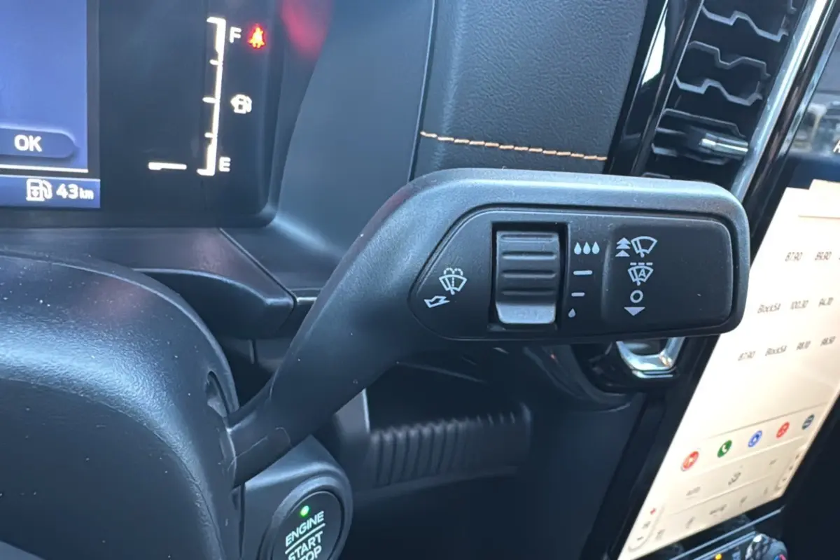 Gros plan sur la commande d’essuie-glace à gauche du volant dans l’habitacle noir du Ford Ranger Cyber Orange 2026.