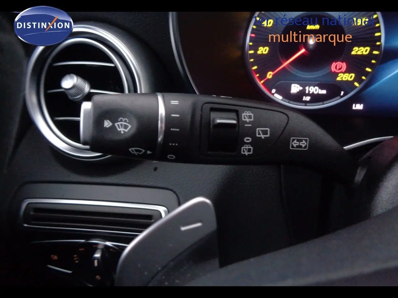 Gros plan sur la commande d’essuie-glace à gauche du volant dans l’habitacle noir du Mercedes Classe C Break 220D AMG Line.