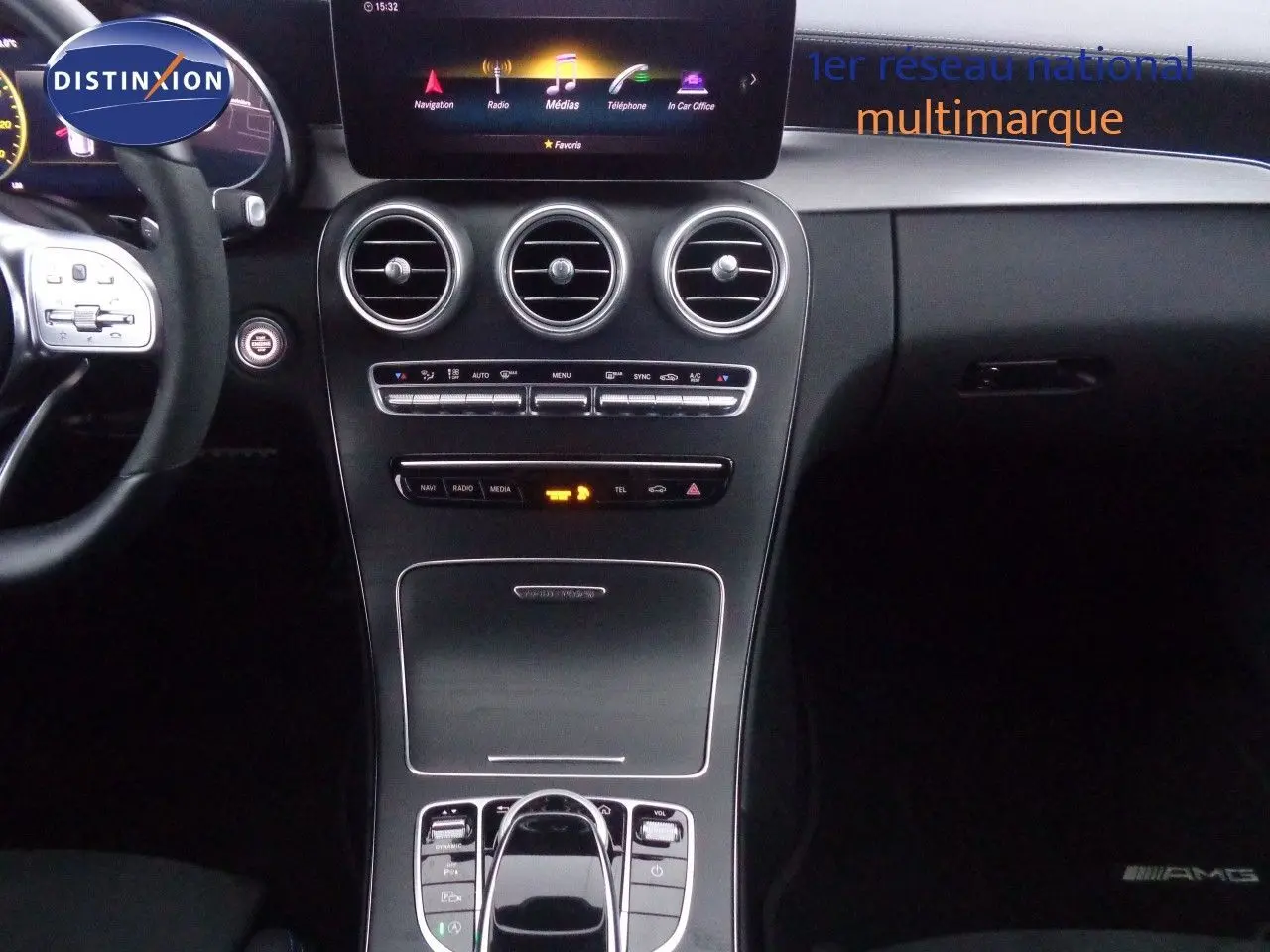 Vue intérieure centrée sur la console et le volant d'une Mercedes Classe C Break 220D noire avec finition AMG Line.