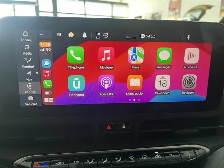Écran tactile central de la Fiat 500 électrique 2020 affichant Apple CarPlay avec icônes colorées sur fond rouge et violet