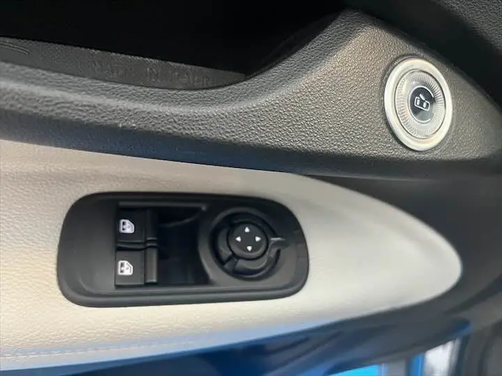 Gros plan sur les commandes de verrouillage et réglage des rétroviseurs côté conducteur de la Fiat 500 électrique gris minéral.