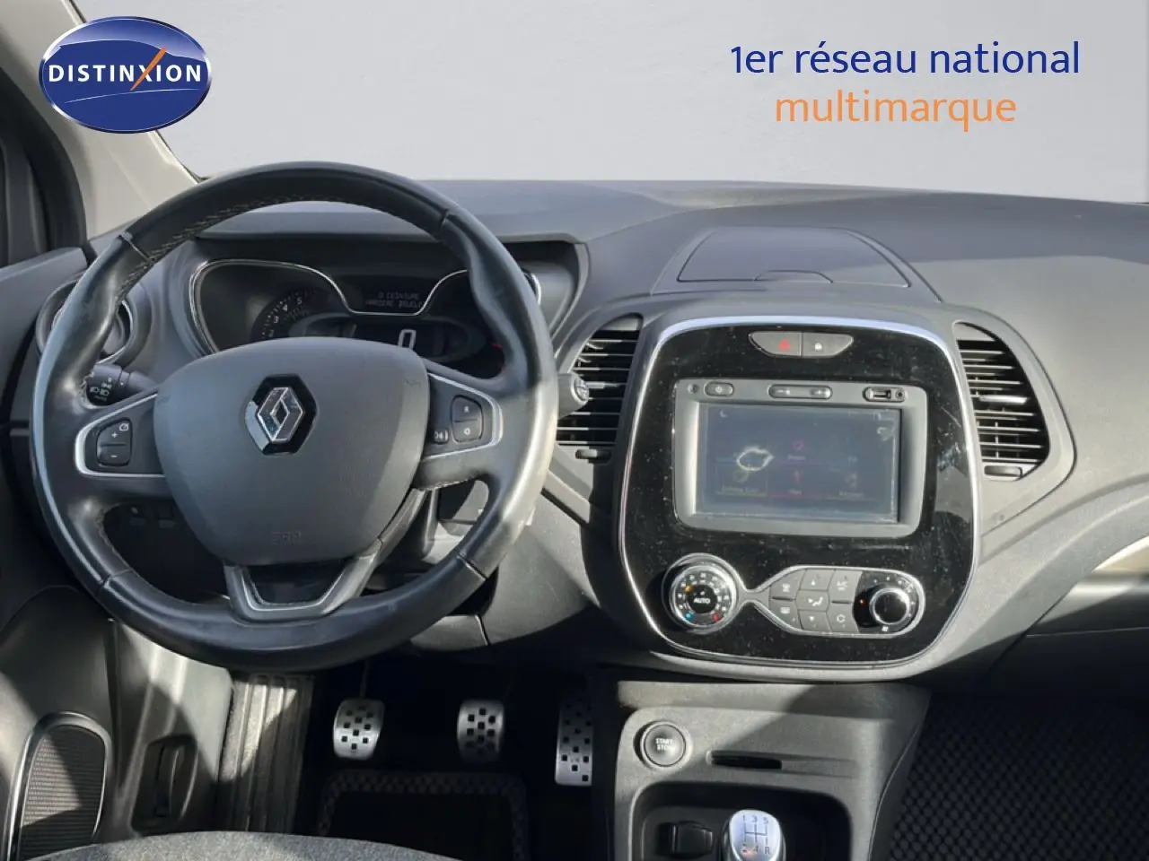 Vue intérieure centrée sur le volant et la console centrale du Renault Captur gris, version Intens 2019 avec boîte manuelle.