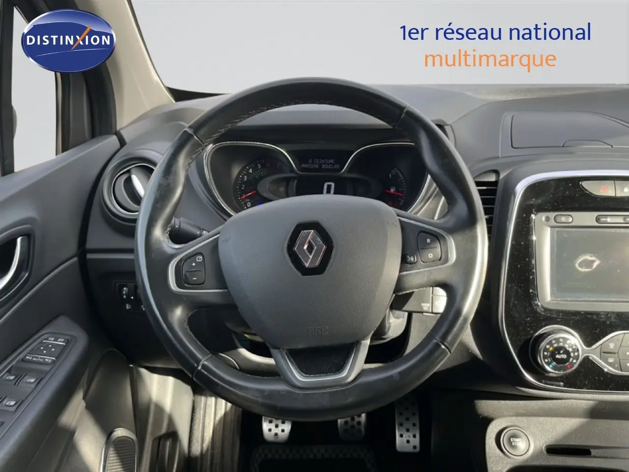 Vue intérieure centrée sur le volant noir du Renault Captur gris 2019, avec tableau de bord et console tactile visibles.