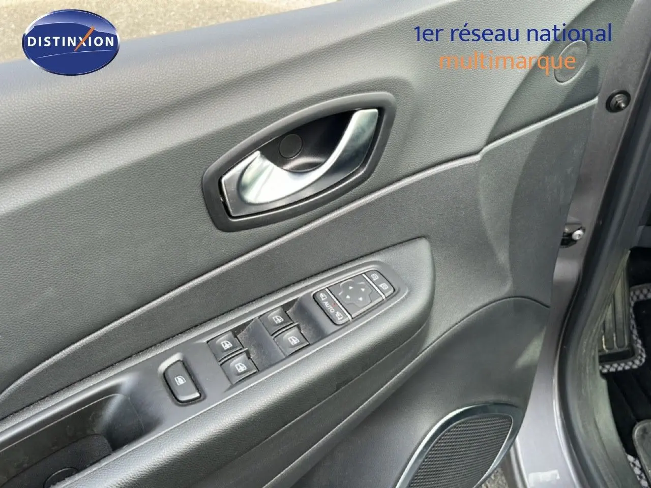 Vue rapprochée de la porte avant gauche grise du Renault Captur 2019 avec commandes électriques des vitres et poignée chrome.
