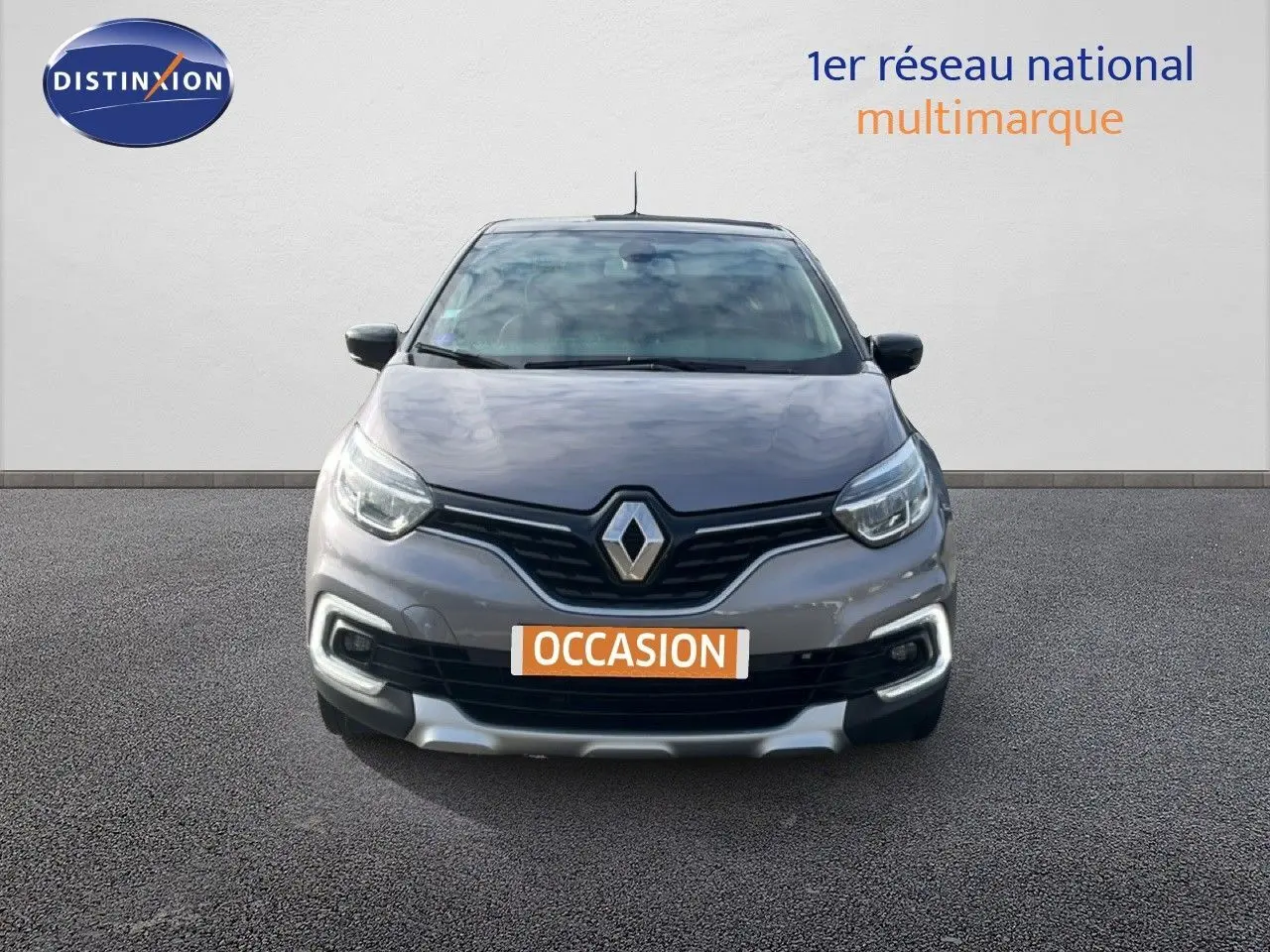 Vue frontale d'un Renault Captur gris 2019 avec calandre noire et plaque "OCCASION" visible.