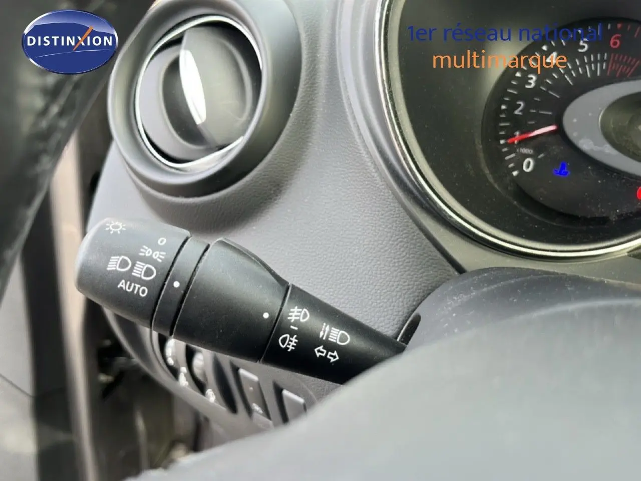Gros plan sur la commande des phares à gauche du volant du Renault Captur gris, tableau de bord partiellement visible.