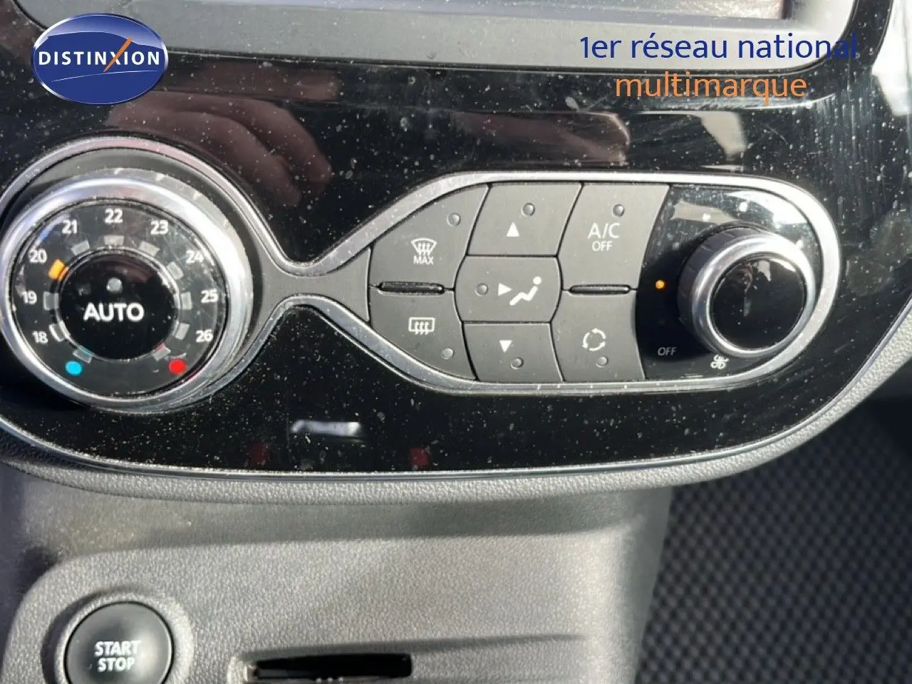 Gros plan sur la console centrale du Renault Captur gris 2019, montrant les commandes de climatisation et le bouton start/stop.