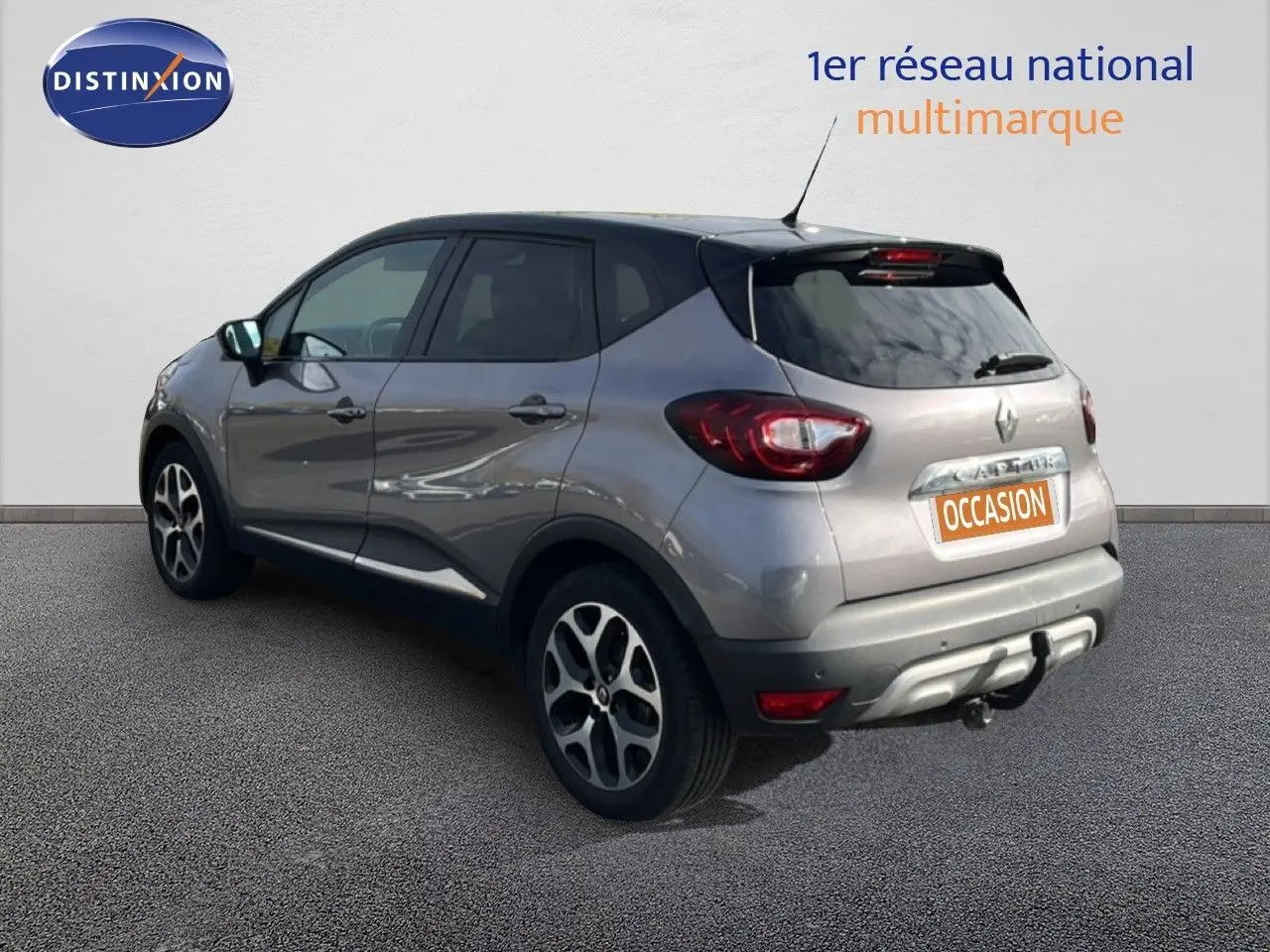 Vue 3/4 arrière droite d’un Renault Captur gris 2019 avec attelage et jantes alliage distinctives.