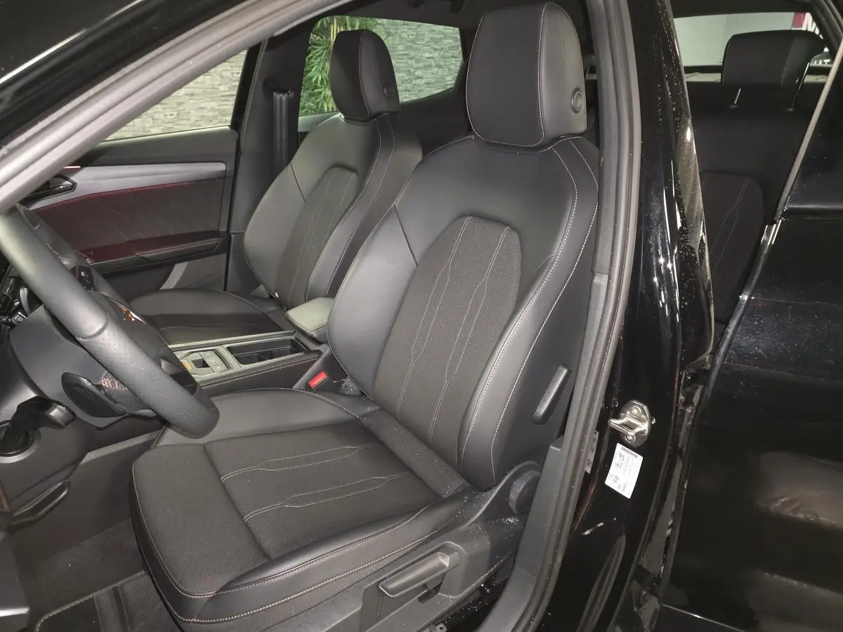 Vue intérieure côté conducteur du CUPRA Formentor noir, sièges sport bimatière avec surpiqûres cuivrées visibles.