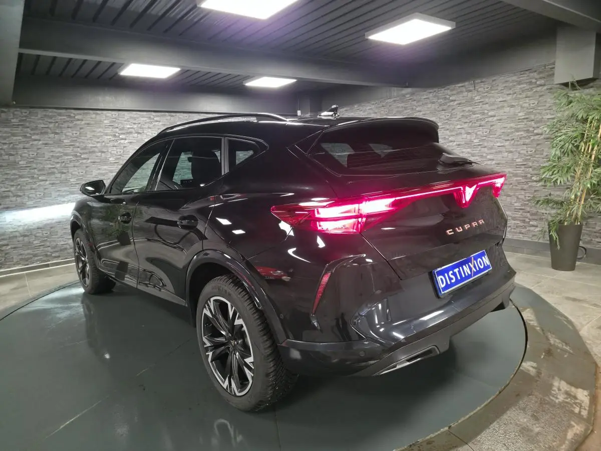 Vue 3/4 arrière droite d'un CUPRA Formentor noir avec feux arrière Tri-LED et jantes alliage 18'' usinées.