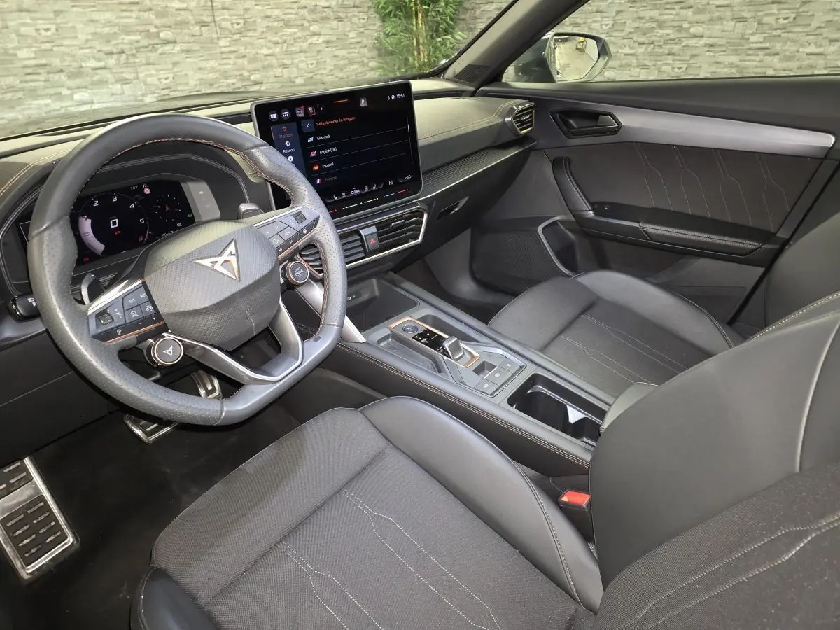 Vue intérieure côté conducteur du CUPRA Formentor noir, avec volant multifonction, écran tactile central et sellerie sport noire.