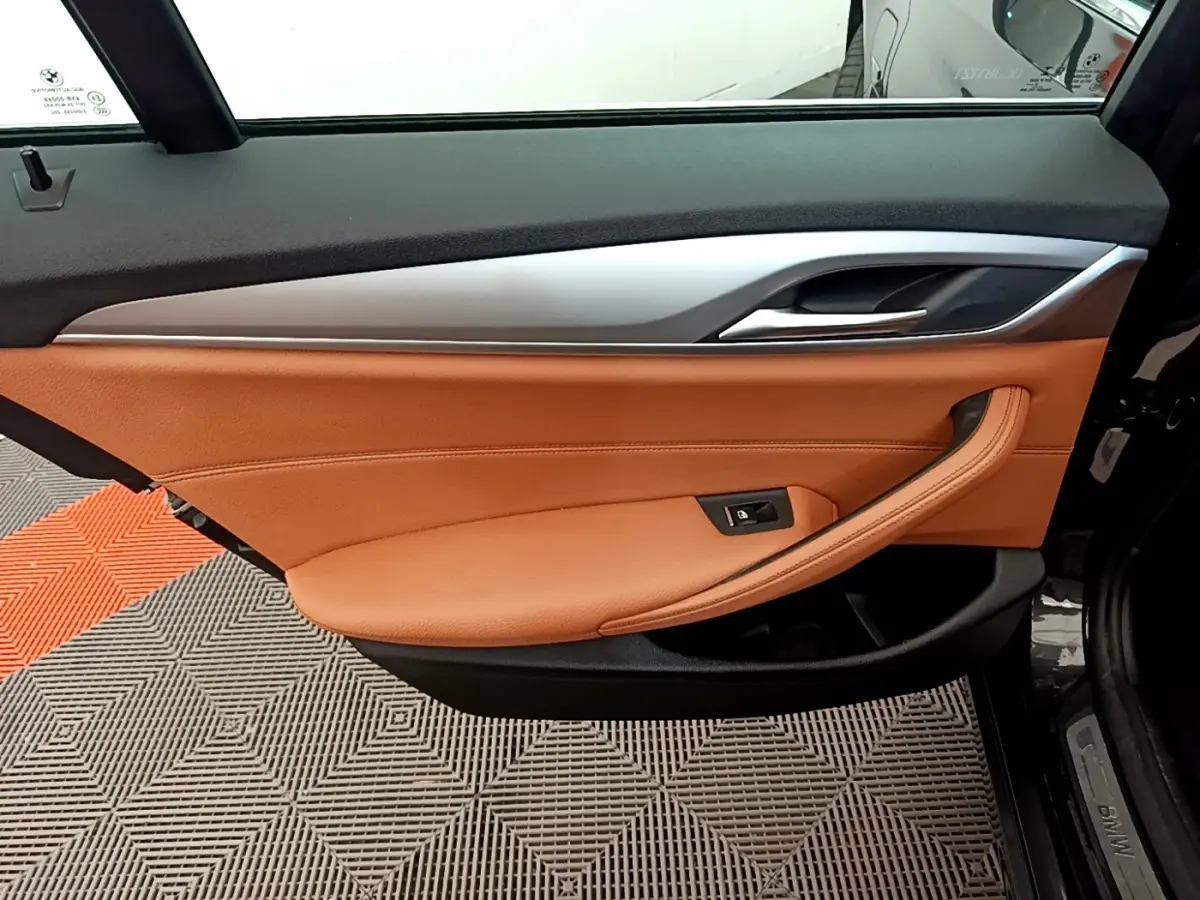 Intérieur de la porte avant droite de BMW Série 5 Touring 530e 2022, cuir marron et garniture aluminium.