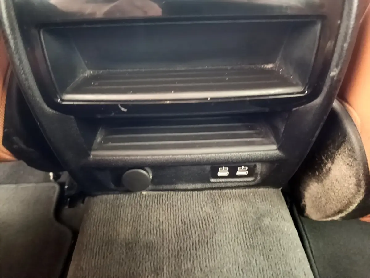 Vue rapprochée de la console arrière noire avec prises USB doubles et prise 12V dans une BMW Série 5 Touring gris clair.