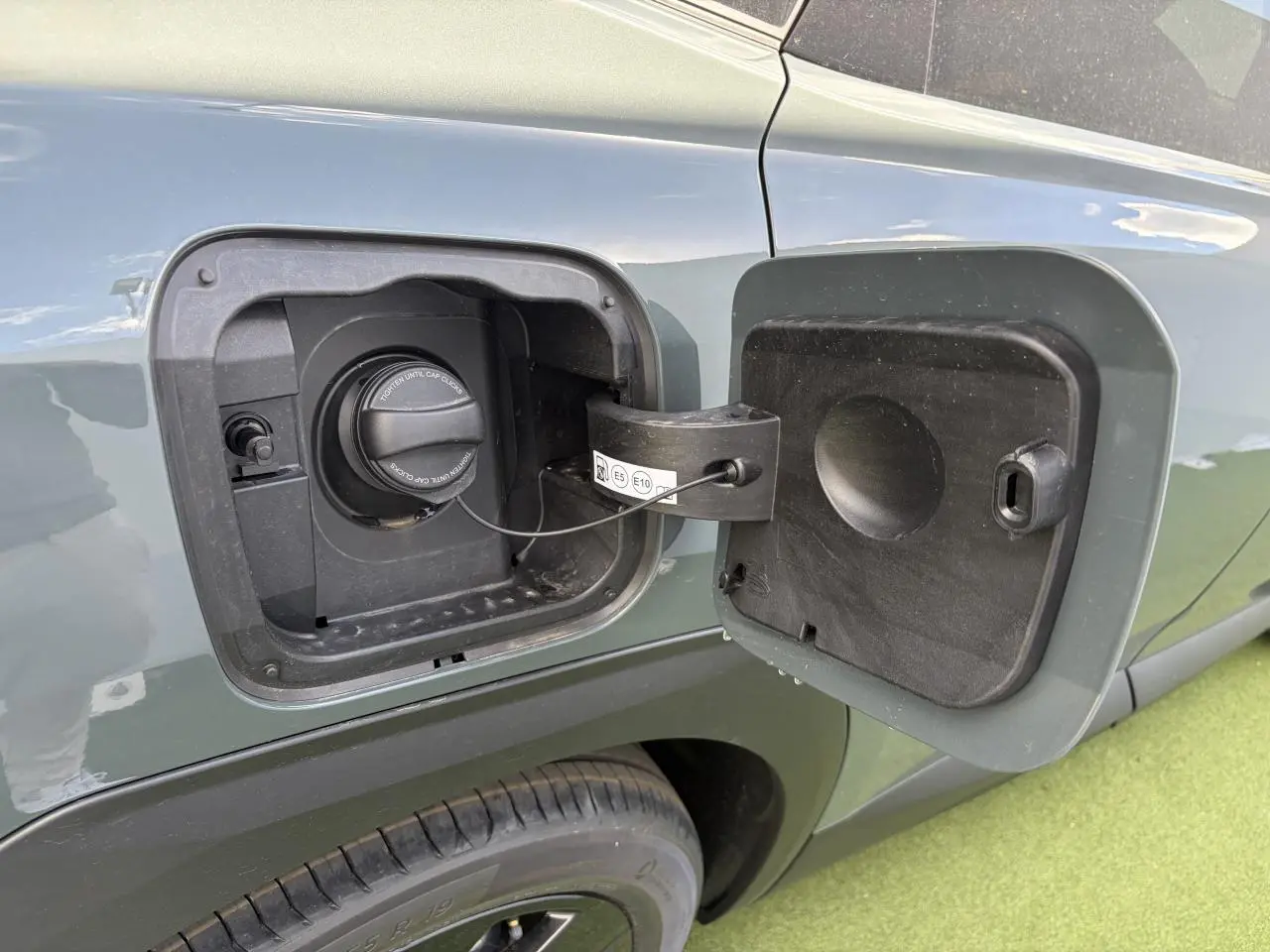 Gros plan sur la trappe à carburant côté gauche d’un Citroën C5 Aircross vert Astoria avec toit noir.