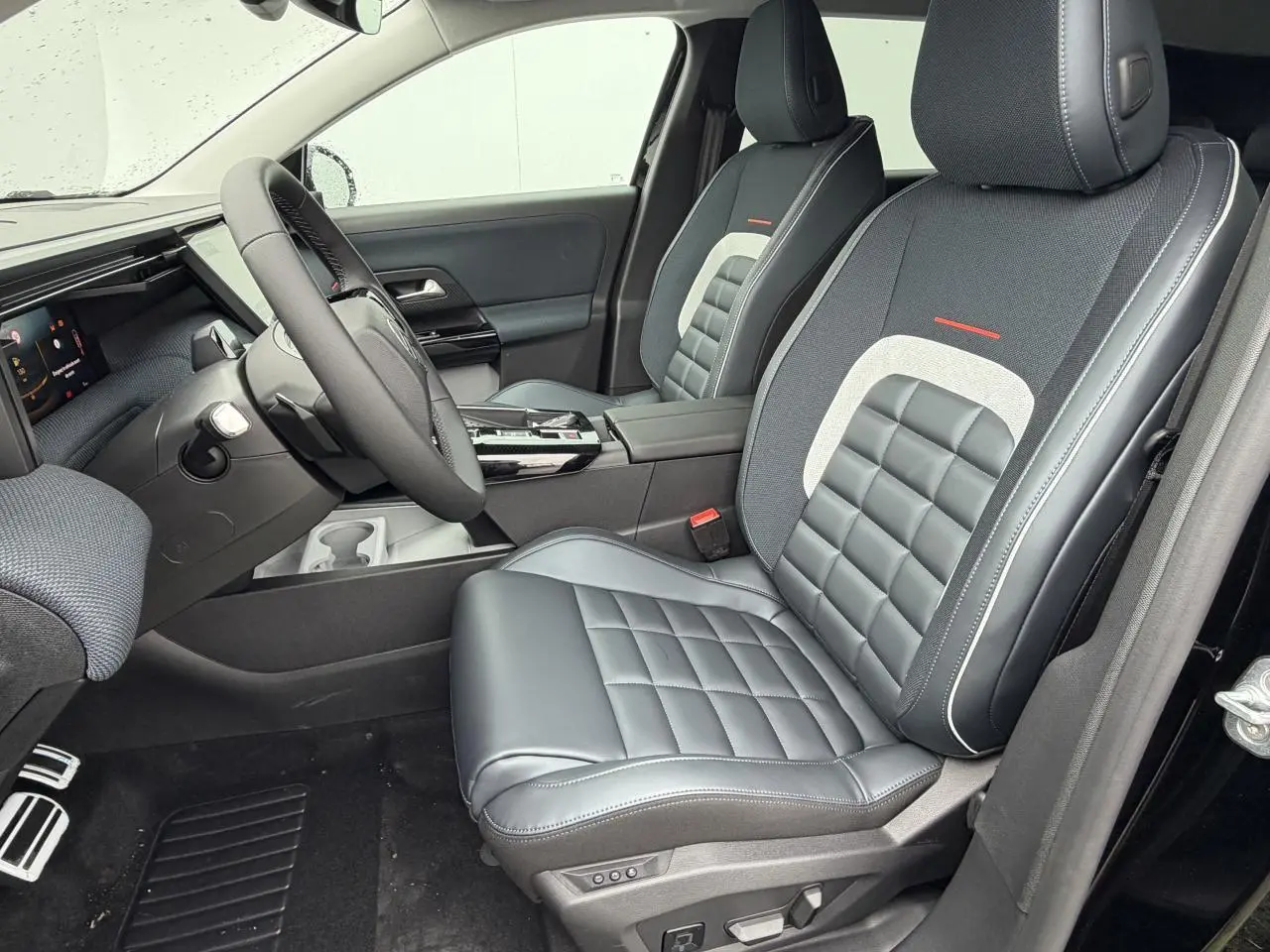 Vue intérieure côté conducteur du Citroën C5 Aircross 2026, sièges cuir et tissu noir avec surpiqûres blanches.