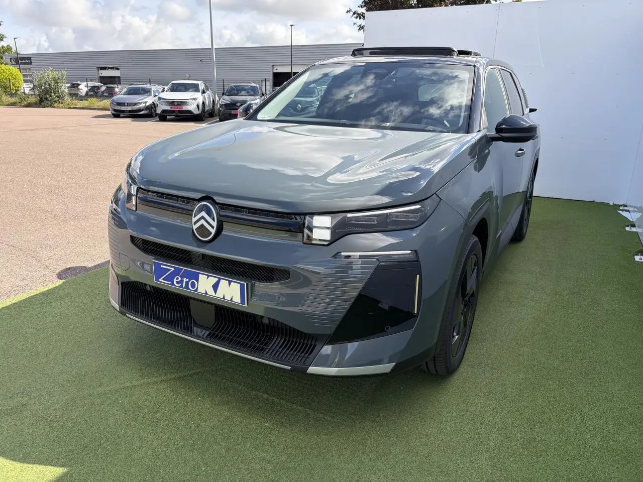 Vue 3/4 avant d'un Citroën C5 Aircross 2026 vert Astoria avec toit noir et calandre moderne.