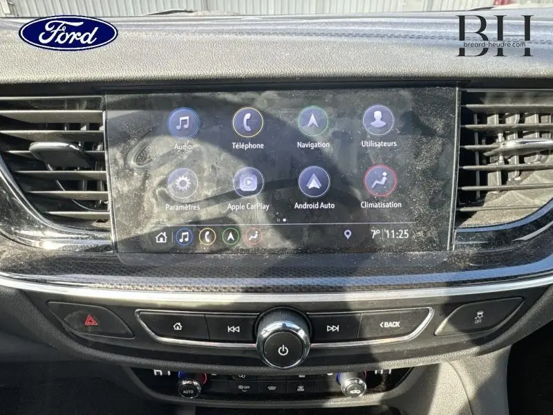 Écran tactile central de l’Opel Insignia Sports Tourer gris Minéral, avec commandes multimédia et climatisation visibles.