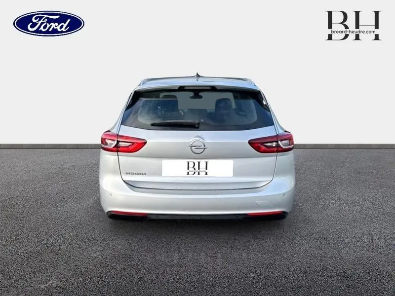 Vue arrière d'une Opel Insignia Sports Tourer gris minéral métallisé avec feux LED et double sortie d'échappement visible.