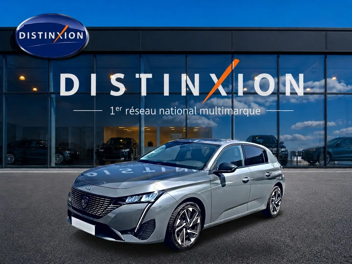 Peugeot 308 gris vue 3/4 avant droit, avec jantes alliage et calandre distinctive, devant showroom Distinxion.
