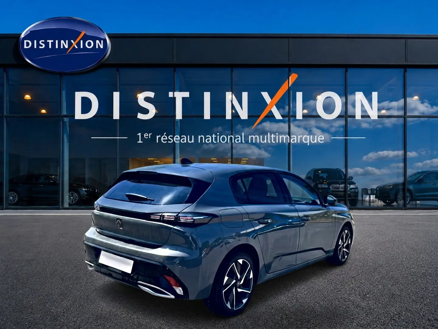 Peugeot 308 gris vue 3/4 arrière droit, avec jantes alu et feux arrière LED, devant vitrine Distinxion.