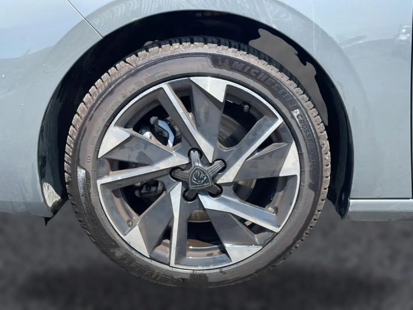 Gros plan sur la roue arrière droite grise d'une Peugeot 308 1.5 BlueHDi 130 Allure avec jante alu distinctive.