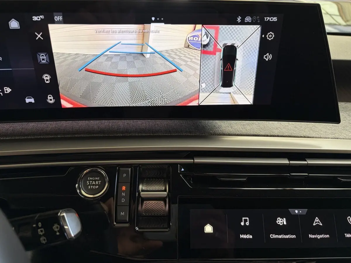 Vue rapprochée de l’écran tactile central du tableau de bord du Peugeot 5008 Hybrid, affichant la caméra de recul et commandes de boîte auto.