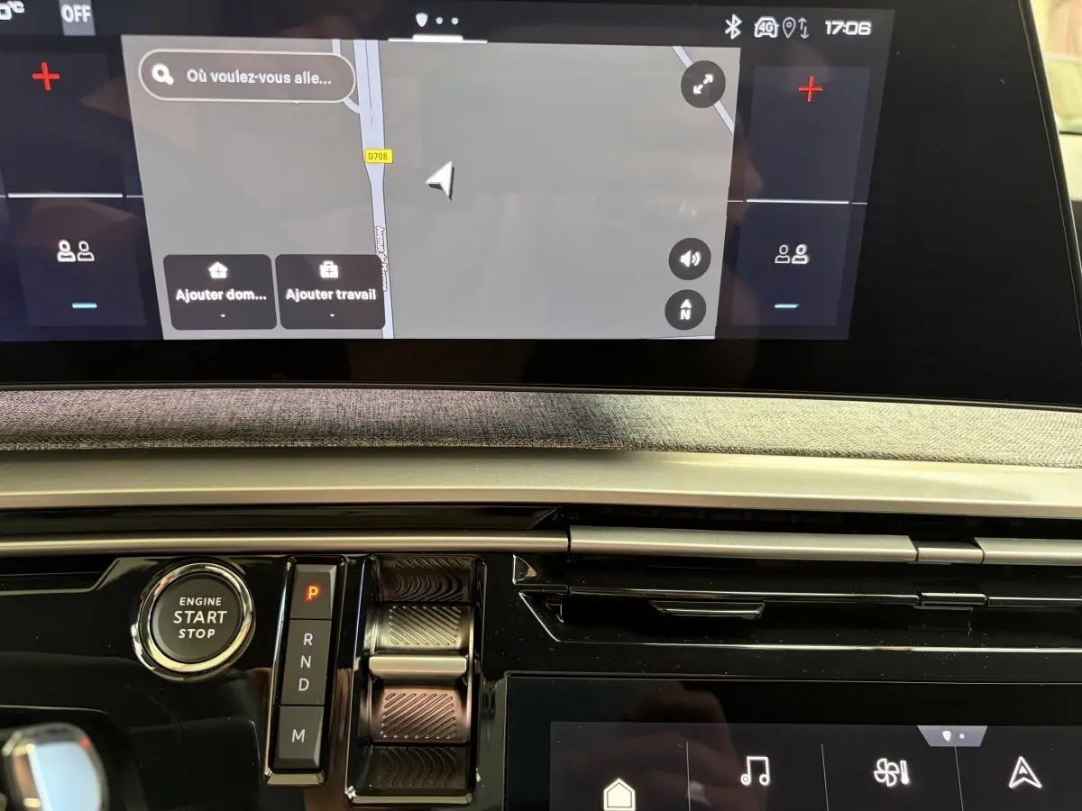 Vue rapprochée du tableau de bord du Peugeot 5008 hybride 2025, avec écran tactile et commande de boîte automatique.
