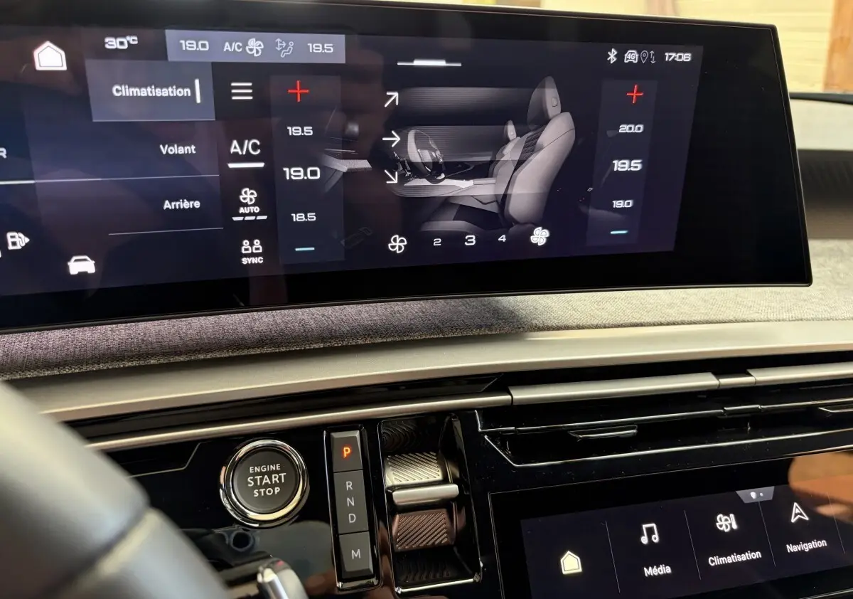 Vue intérieure du tableau de bord du Peugeot 5008 hybride 2025 avec écran tactile et bouton démarrage, ambiance moderne.