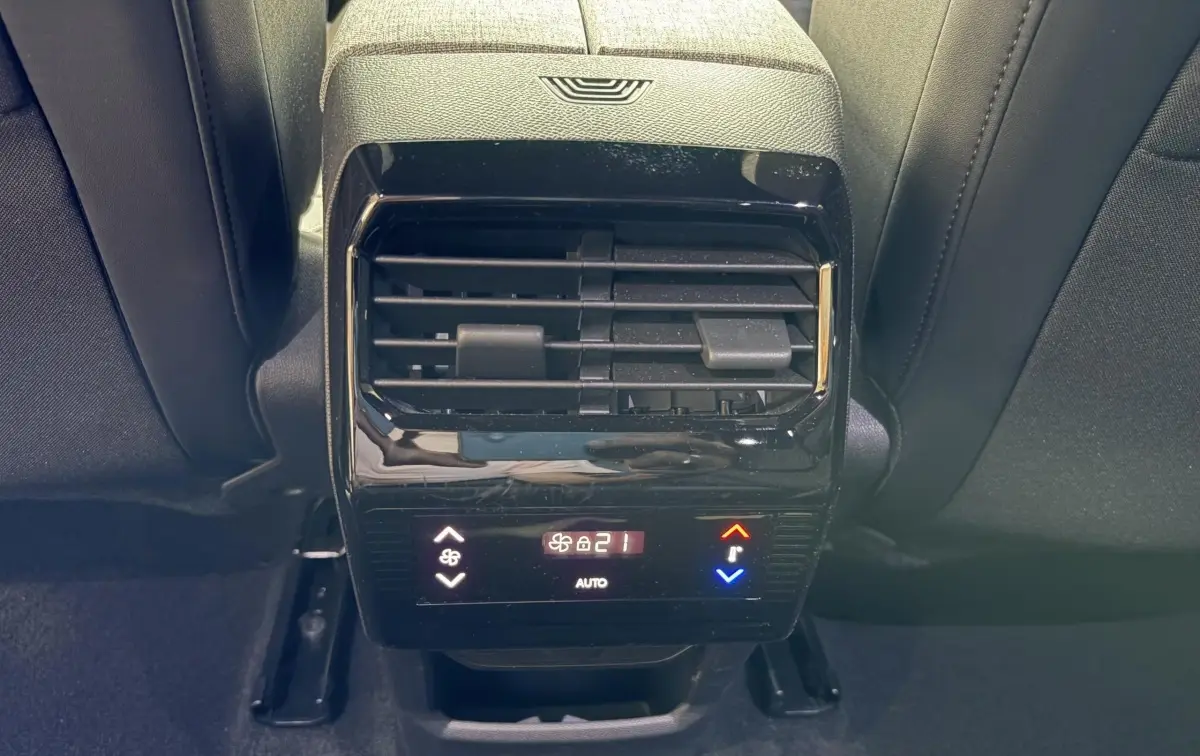 Détail de la commande de climatisation arrière noire du Peugeot 5008 Hybrid 145 vue de face entre les sièges arrière.
