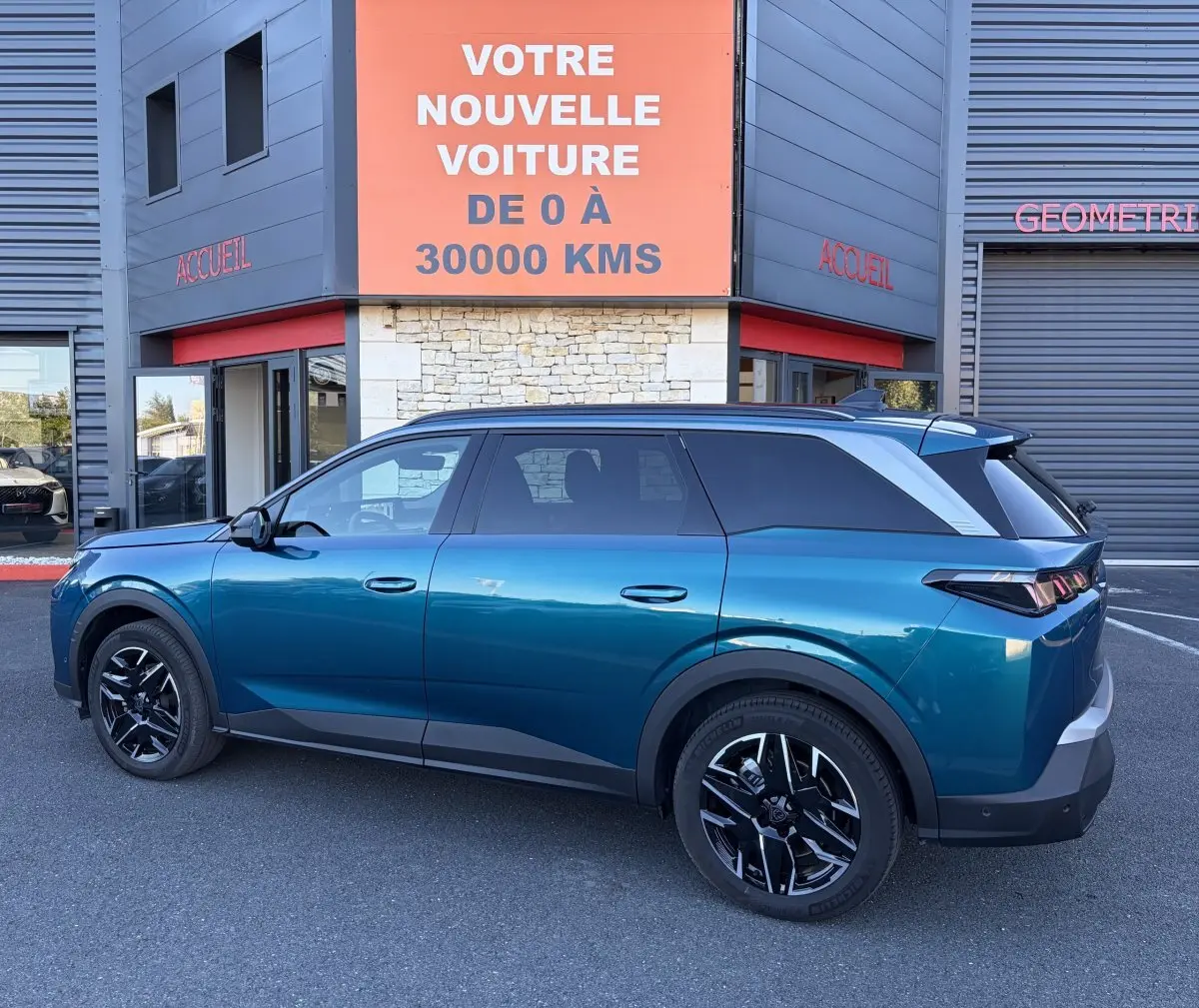 Peugeot 5008 hybride vert vue de profil côté gauche, soulignant ses jantes noires et son design moderne.