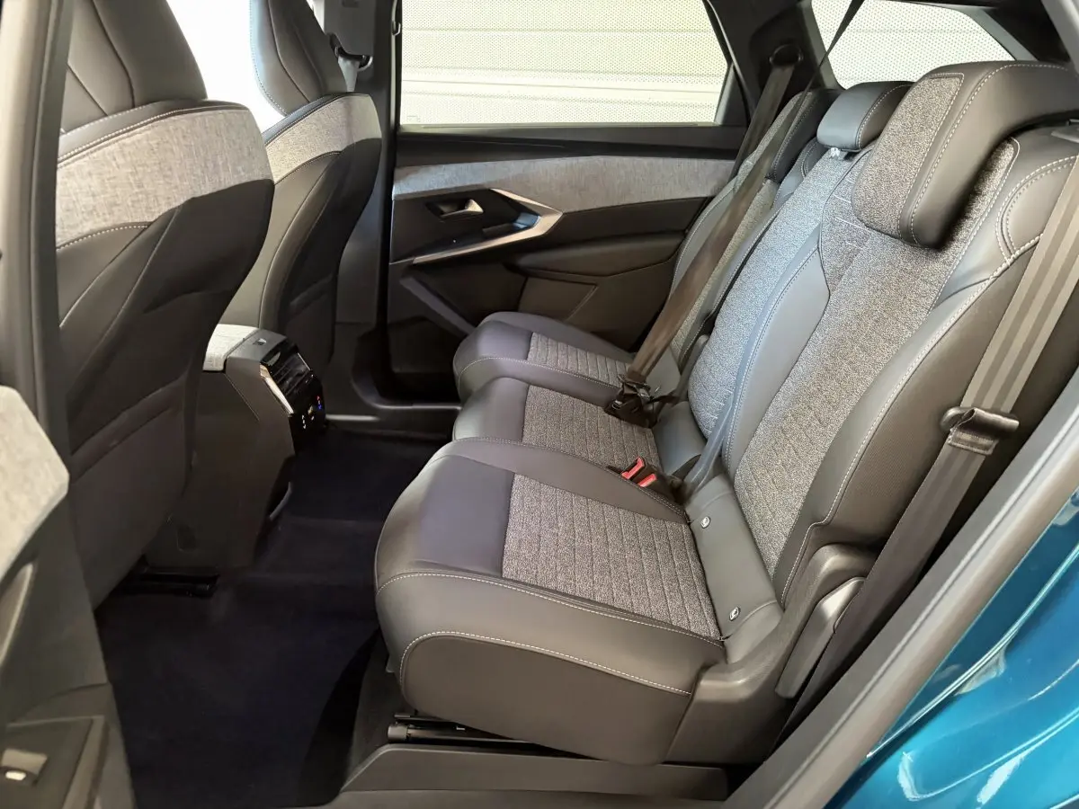 Vue intérieure côté droit sur la banquette arrière grise et tissu du Peugeot 5008 vert avec porte ouverte.