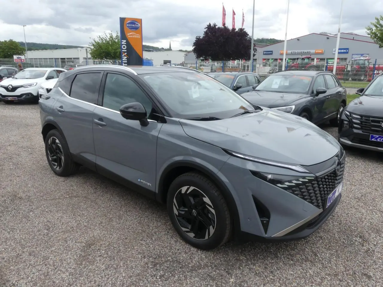 Nissan Qashqai 1.5 e-Power gris métallisé en 3/4 avant droit avec toit noir et jantes alliage noires.
