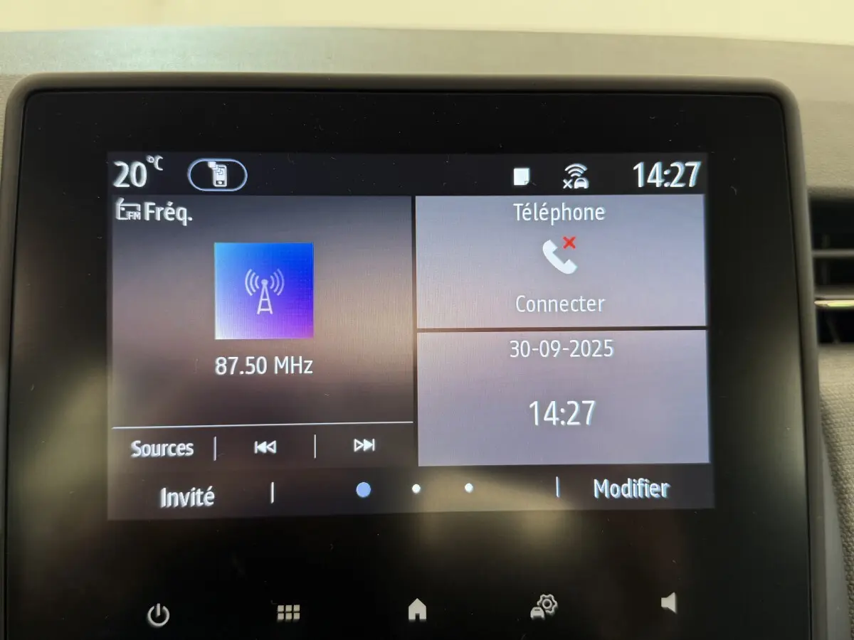 Écran tactile central de la Renault Clio noire 2025 affichant la radio FM et la connexion téléphone