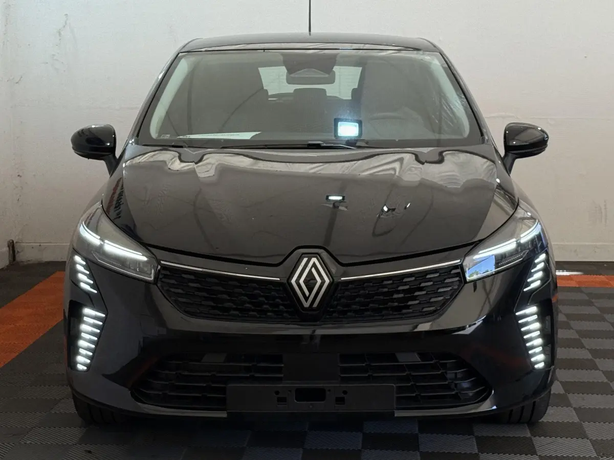 Vue frontale d'une Renault Clio noire 2025 avec feux LED verticaux et calandre noire brillante.