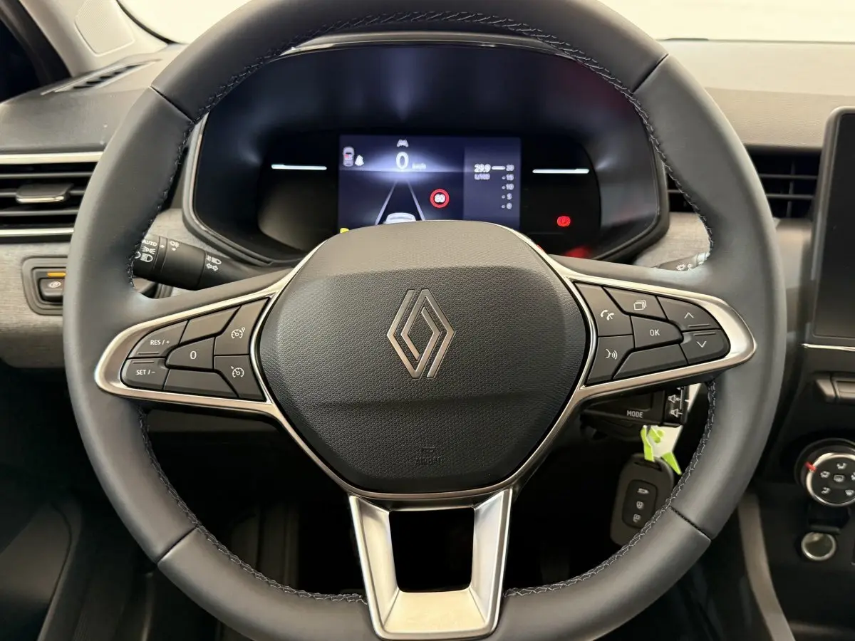 Volant cuir noir de Renault Clio 2025 vu de face avec commandes multifonctions et tableau de bord numérique.
