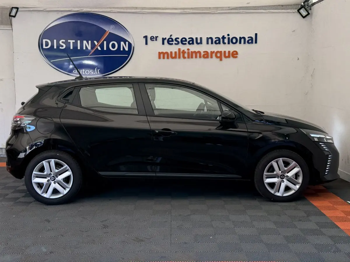 Profil latéral droit d'une Renault Clio noire 2025 avec feux LED et jantes alliage en showroom.