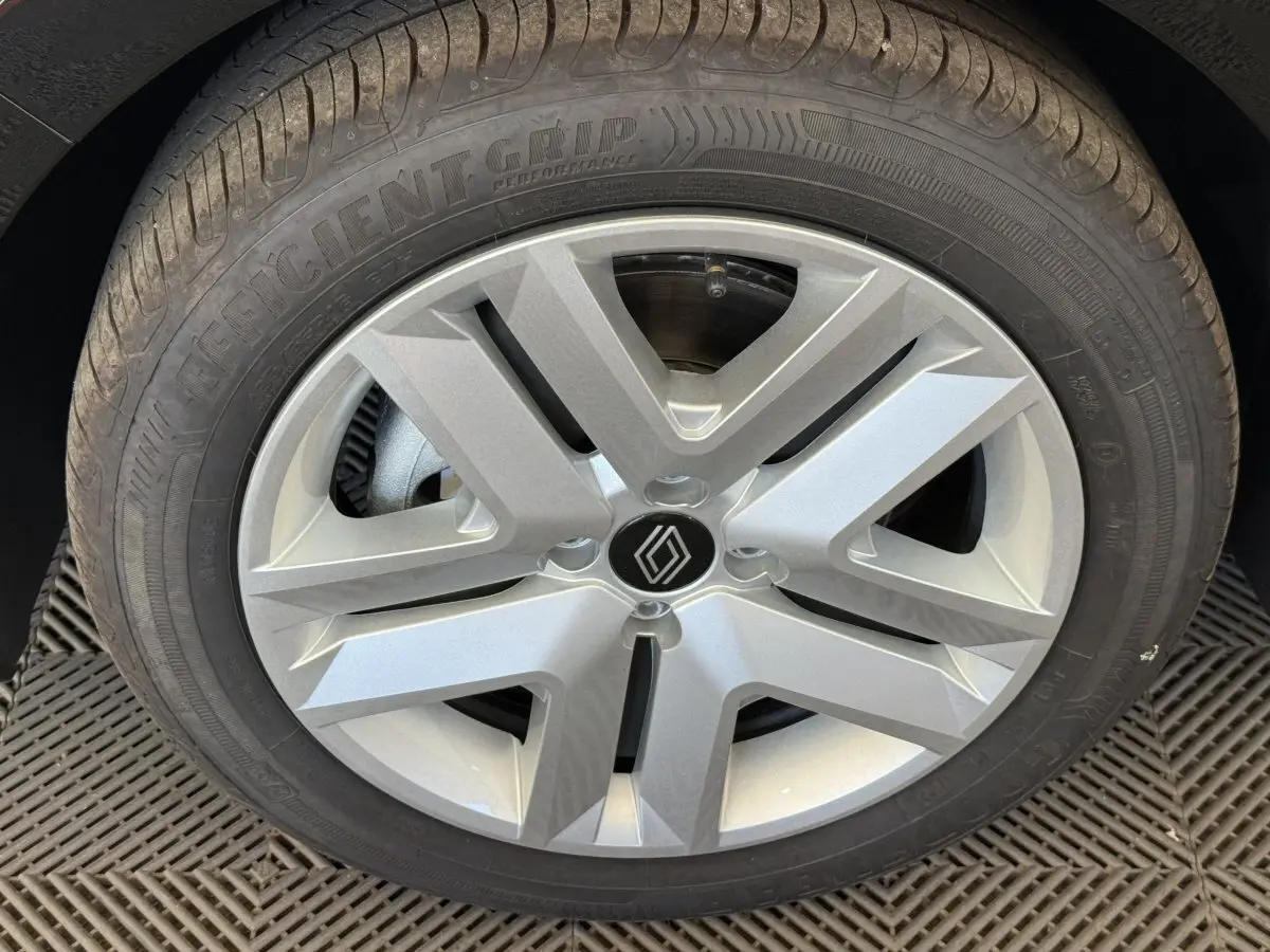Gros plan sur la roue avant droite de la Renault Clio noire 2025, mettant en valeur la jante argentée au design moderne.