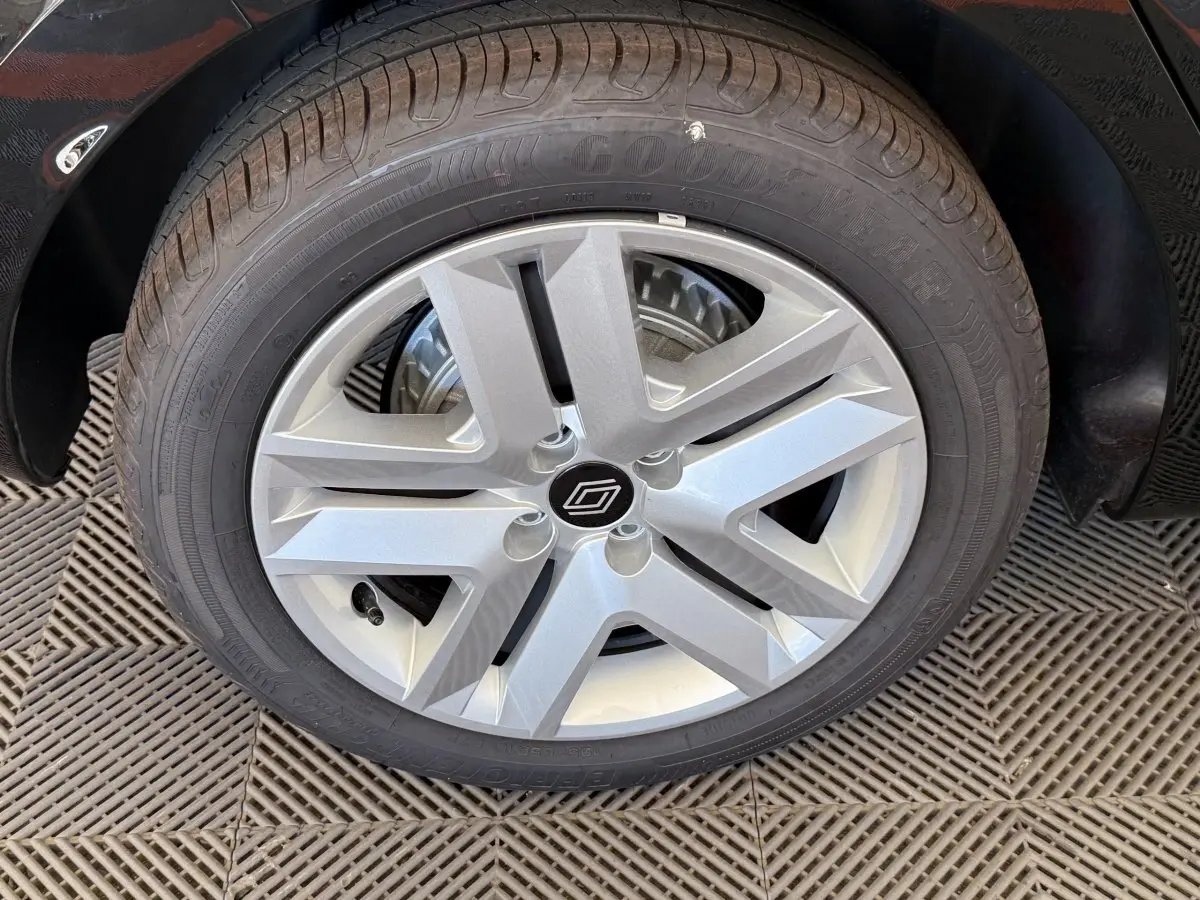 Gros plan sur la roue avant gauche de la Renault Clio noire, mettant en valeur la jante argentée au design moderne.
