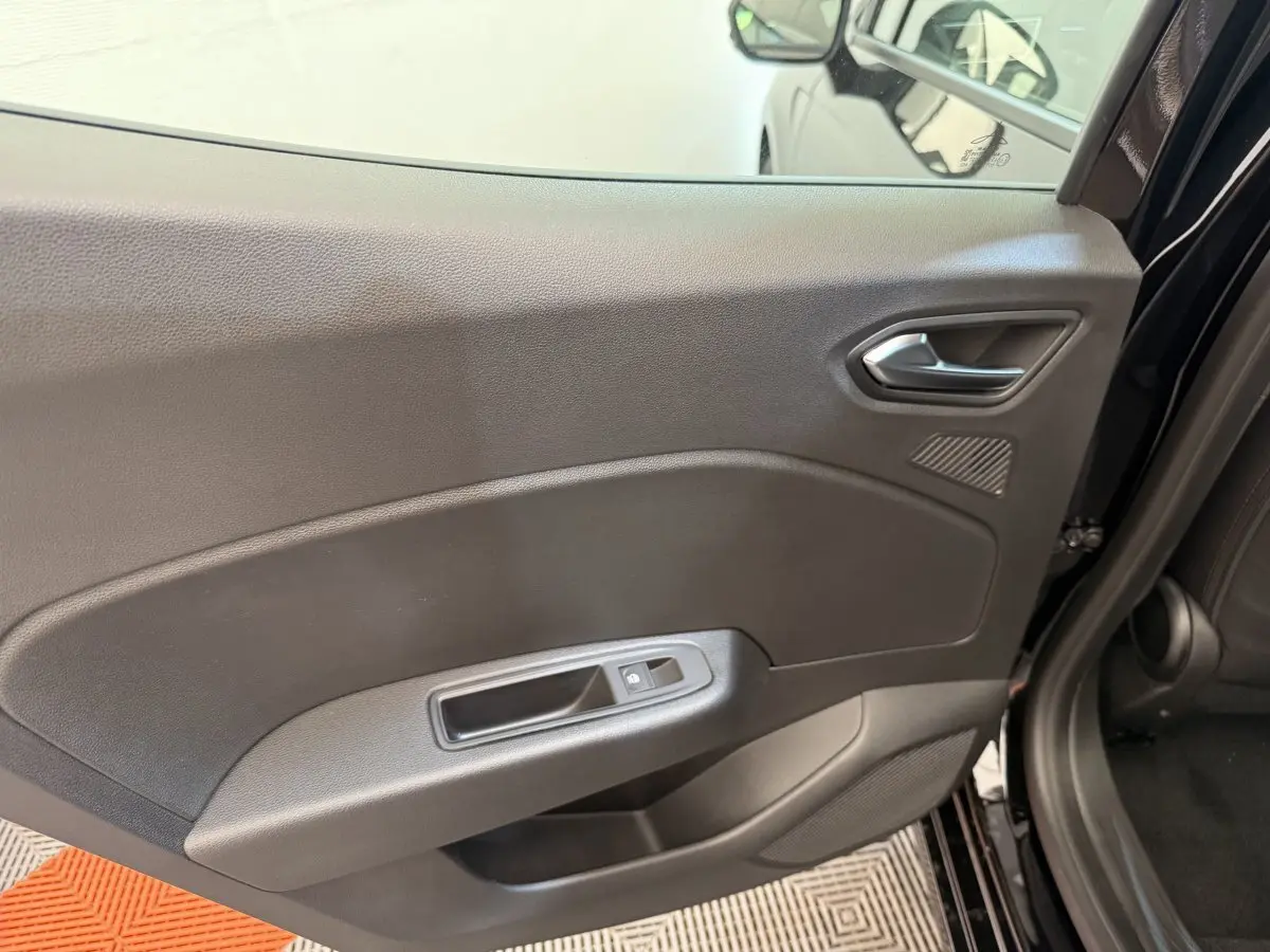Vue rapprochée de la porte arrière droite noire de la Renault Clio 2025 avec poignée et commande de vitre électrique.