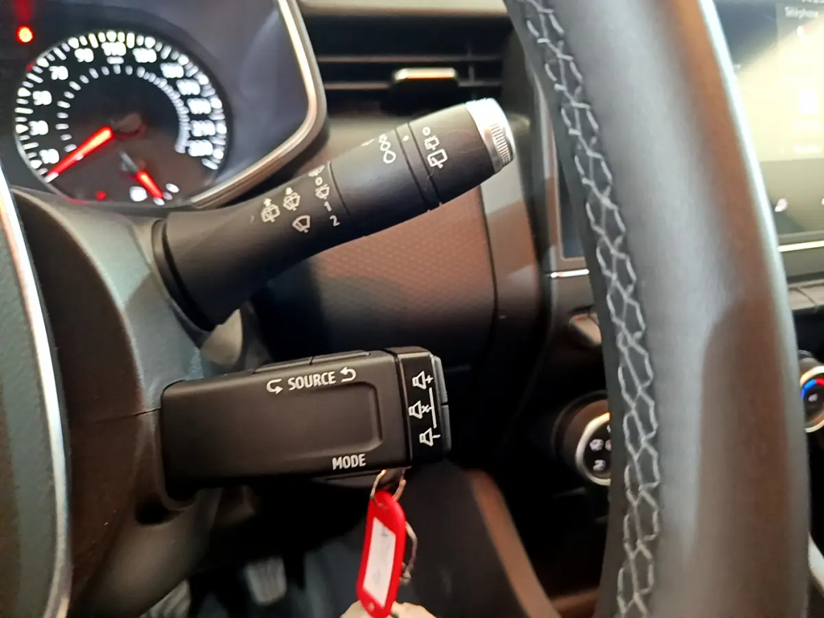 Gros plan sur la commande multifonction à gauche du volant cuir de la Renault Clio Business TCe 100 blanche de 2020.