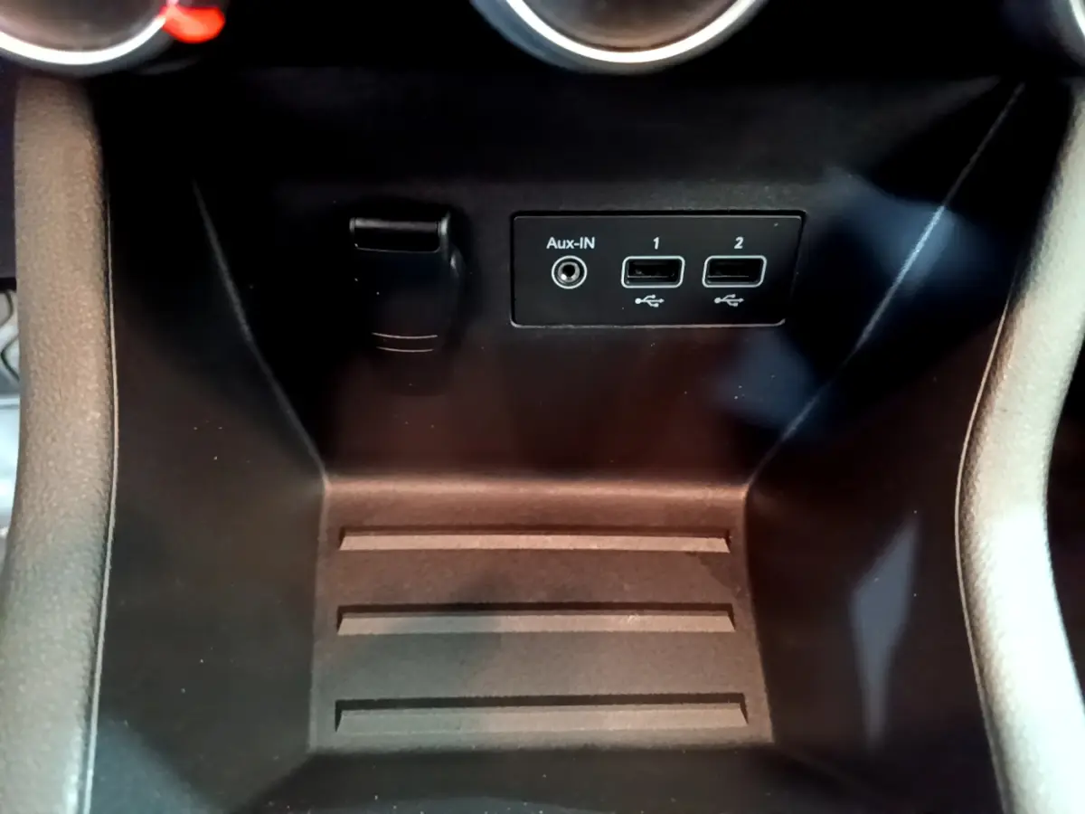 Prise auxiliaire et deux ports USB noirs dans la console centrale d'une Renault Clio Business TCe 100 blanche de 2020.