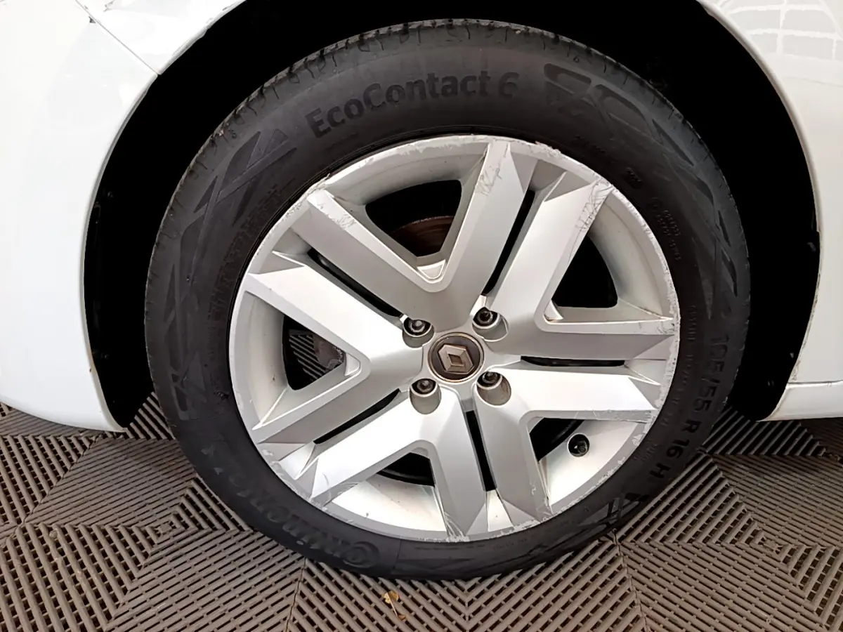 Gros plan sur la roue avant gauche blanche d'une Renault Clio Business TCe 100 de 2020 avec jante alliage griffée.