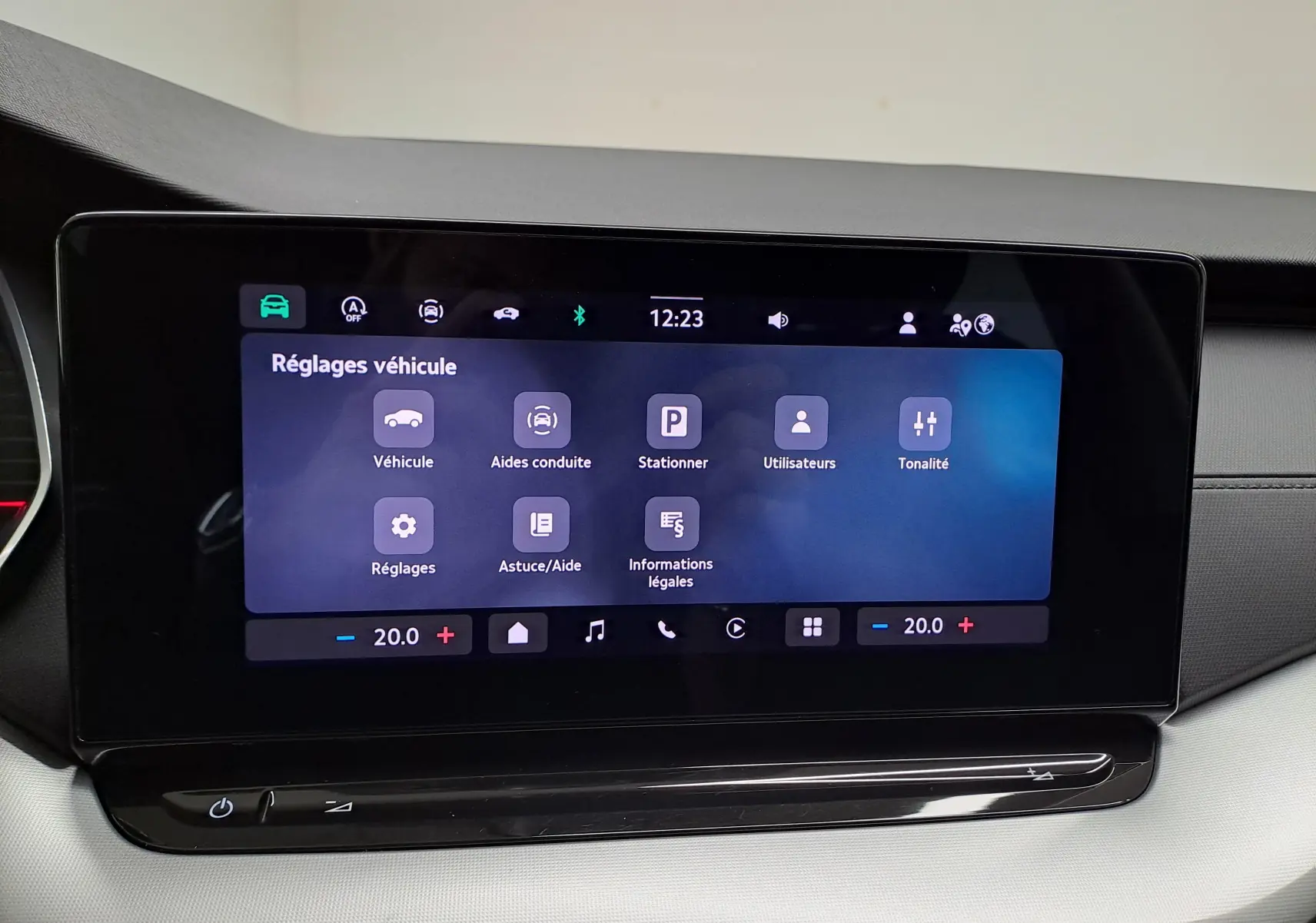 Écran tactile central affichant les réglages véhicule dans l’habitacle d’une Skoda Octavia Combi noir Magic, vue de face.